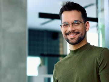 Freelancer im Finanz- und Versicherungsbereich lächelt in die Kamera