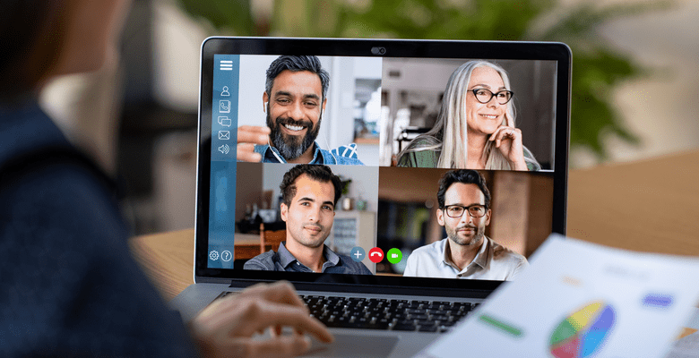 Eine Frau am Laptop nimmt an einem virtuellen Meeting mit 4 Personen teil
