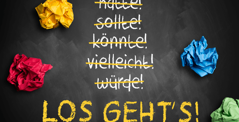 Kreidetafel mit Text und 4 bunten zerknäulten Papierkugeln
