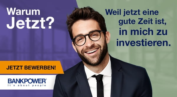 Junger Mann im Business Look mit Bart und Brille, freundlich in die Kamera blickend