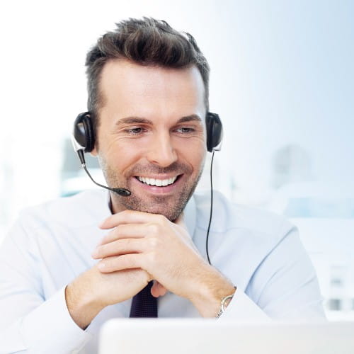 Ausschnitt eines jungen Mannes mit Headset, der in einen Laptop blickt