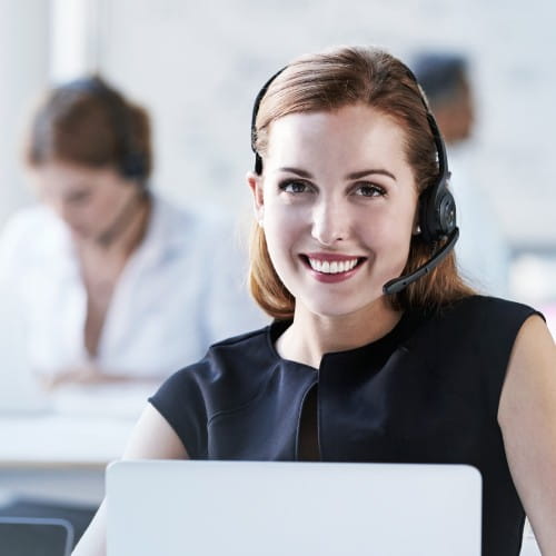 Ausschnitt einer jungen Frau mit Headset vor Ihrem Laptop