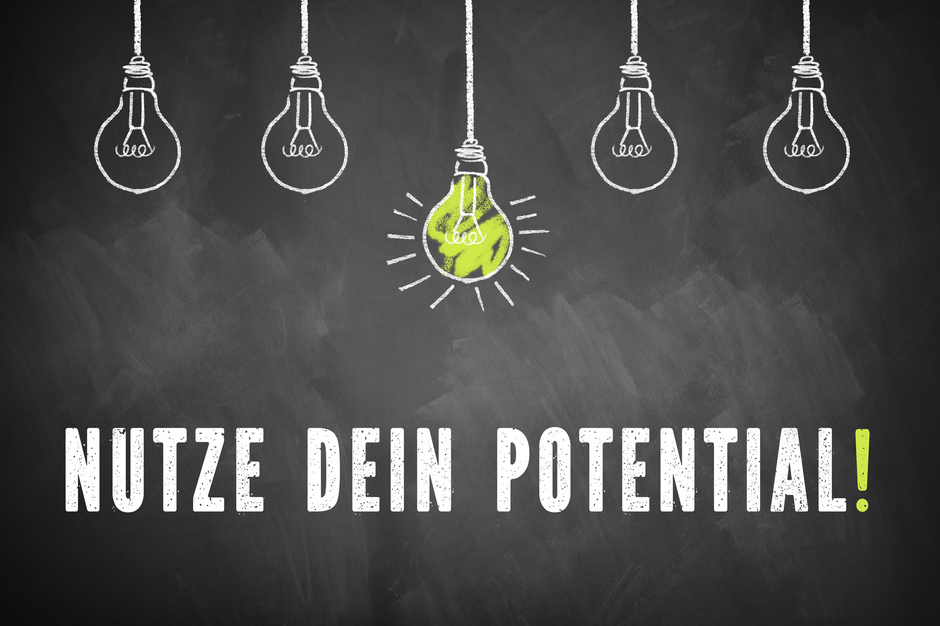 Kreidetafel mit gemalten Glühbirnen und dem Text "Nutze Dein Potential!"